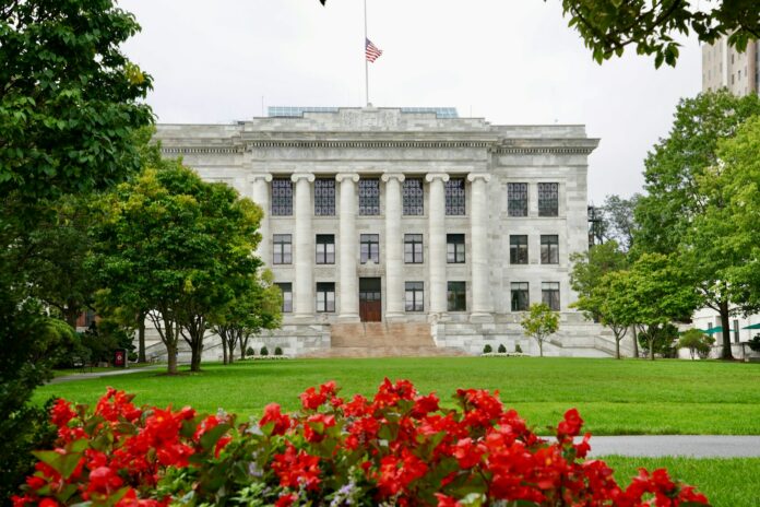 Photo by Brett Wharton a large white building with a flag on top