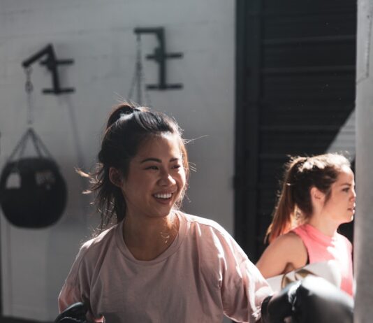 꾸준한 운동이 면역력에 미치는 영향 woman in pink long sleeve shirt and black pants holding black kettle bell