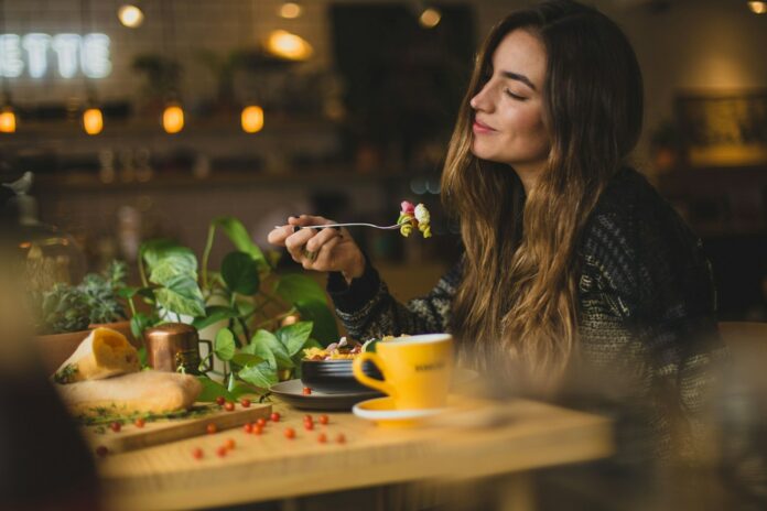 Photo by Pablo Merchán Montes woman holding fork in front table