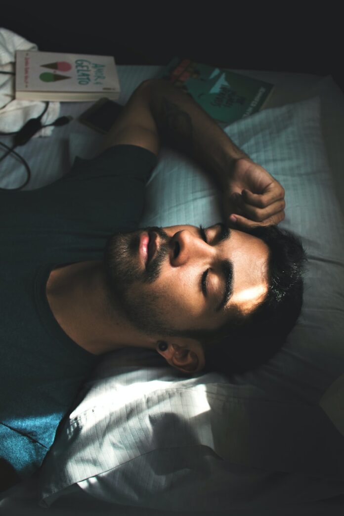 Photo by Lucas Andrade man in black crew neck t-shirt lying on bed