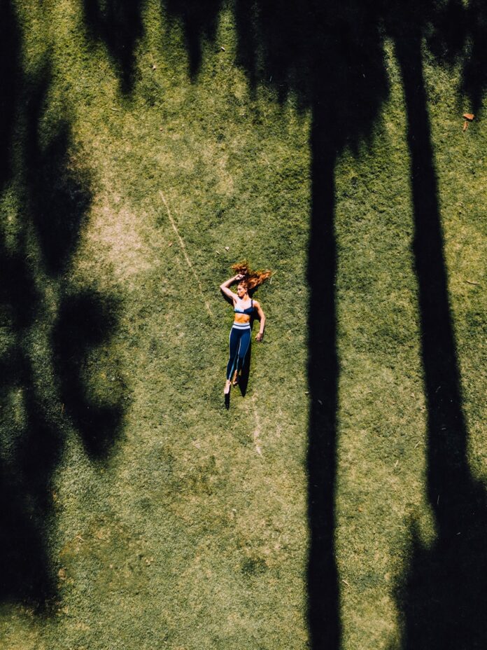 Photo by Gerson Repreza woman lying on green grass during daytime