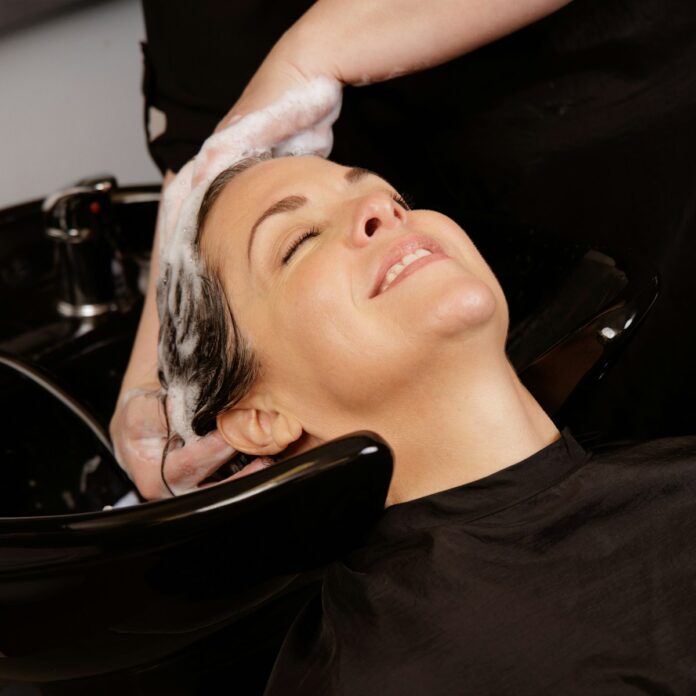Photo by Alexis Duckett A woman enjoys a hair wash at a salon.