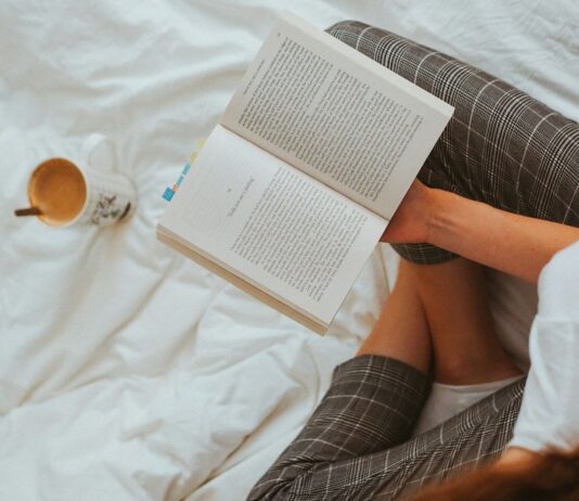 ‘자기 전 스마트폰 멀리하기’…현대인의 숙면, 작은 실천에서 시작된다 person in black and white striped long sleeve shirt reading book