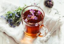 일상으로 스며든 대체요법, 건강한 삶 위한 작은 변화 a glass mug filled with tea next to a bunch of flowers