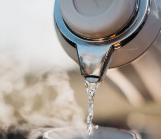 “하루 한 잔, 건강 챙기는 현대인의 물 마시기 루틴” a glass pouring water into a cup